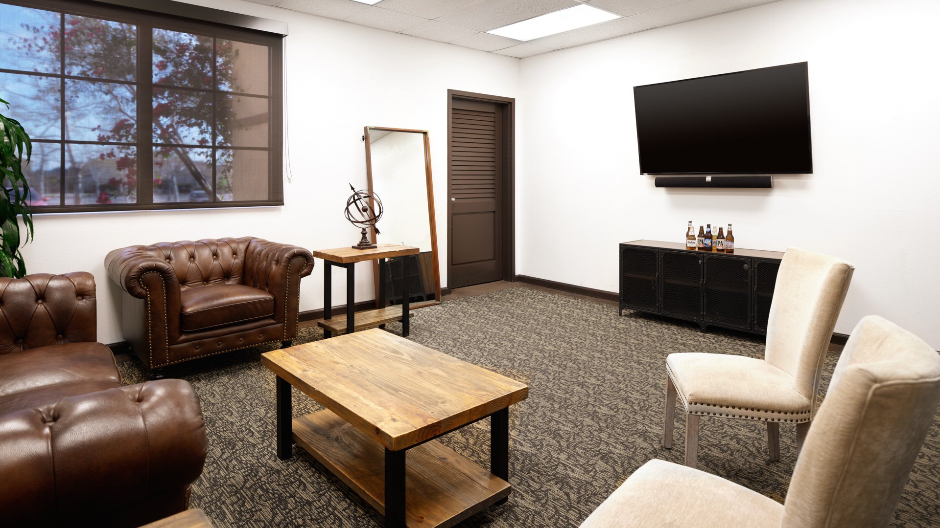 Comfortable private lounge with leather seating, flat screen TV, wet bar, and modern furnishings for wedding parties at Aliso Viejo by Wedgewood Weddings California venue