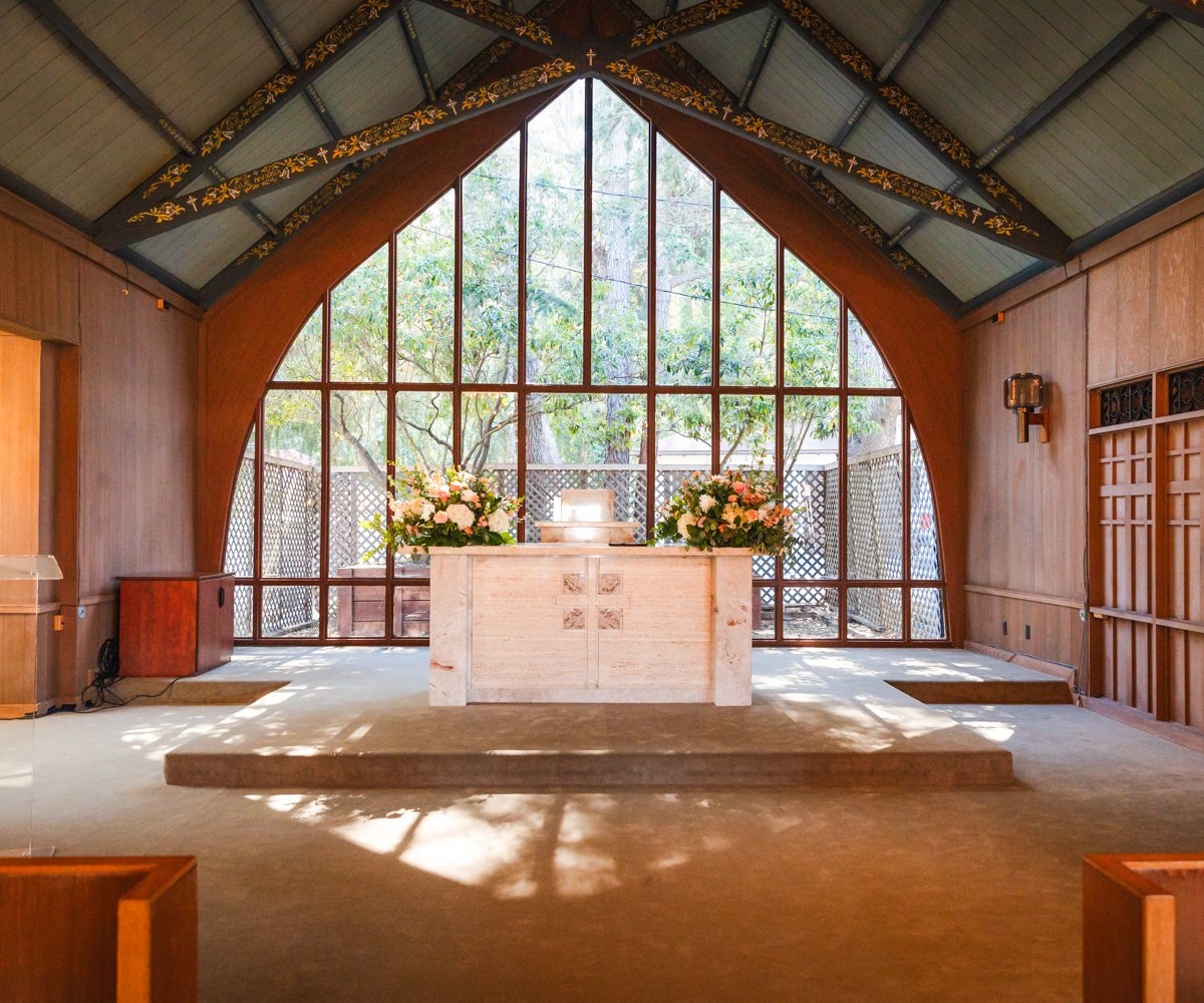 Church altar in front of floor-to-ceiling window with forested views - Chapel of Our Lady at the Presidio - Wedgewood Weddings - 1