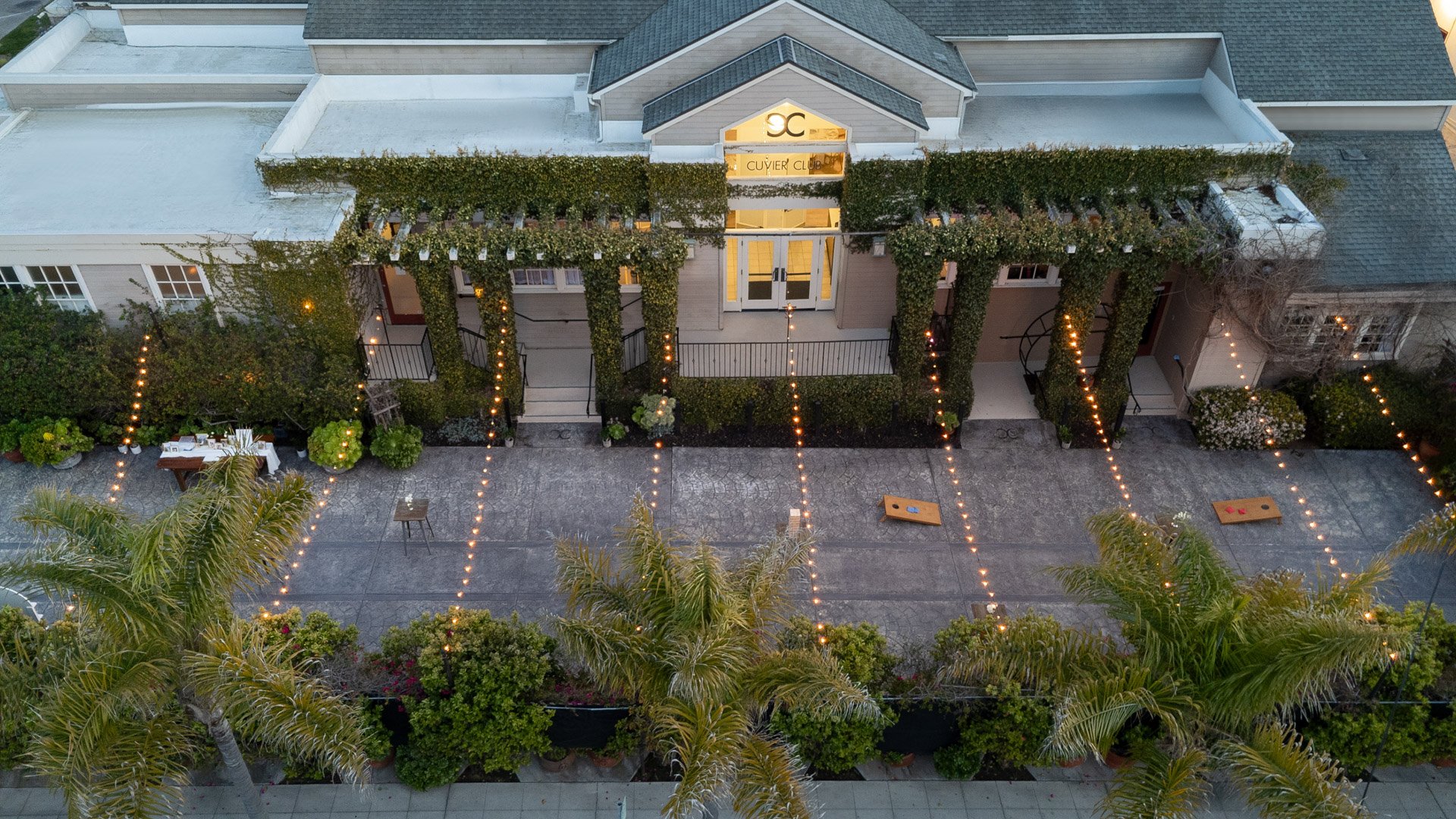 Stunning aerial view of Cuvier Club by Wedgewood Weddings in La Jolla showing the ivy-covered venue exterior, Garden Courtyard, and string light installation for weddings