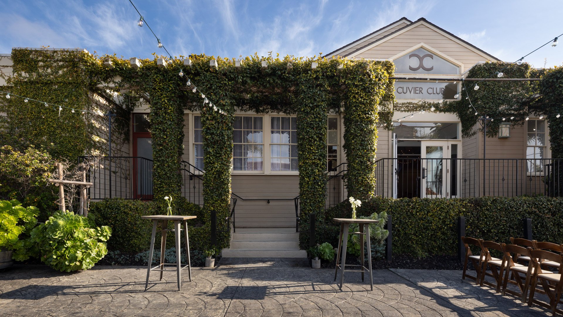 Charming ivy-covered exterior of Cuvier Club by Wedgewood Weddings in La Jolla with cocktail setup, string lights, and classic California architecture perfect for outdoor wedding celebrations