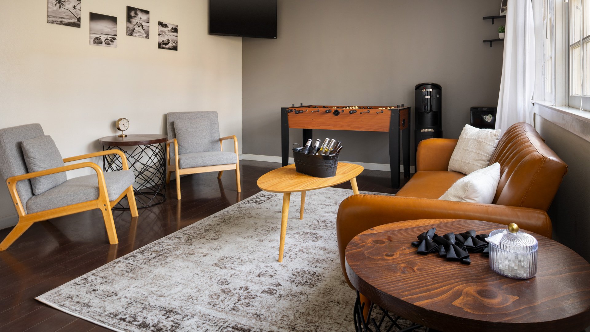 Modern Lounge Suite at Cuvier Club La Jolla featuring leather seating, foosball table, flat-screen TV, and mid-century modern furniture for pre-wedding relaxation