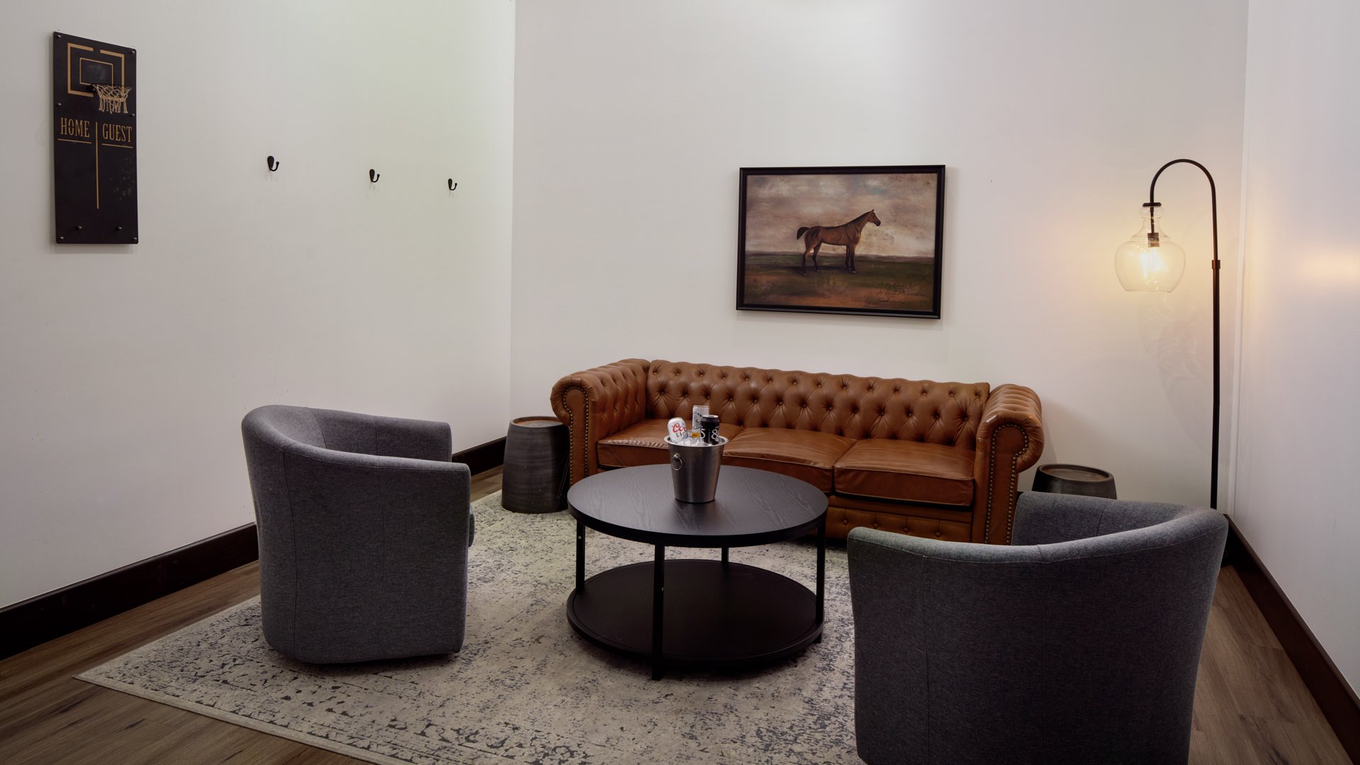 Elegant lounge room at Fallbrook Estate Wedgewood Weddings with leather Chesterfield sofa, modern chairs, equestrian artwork, and comfortable lounge area