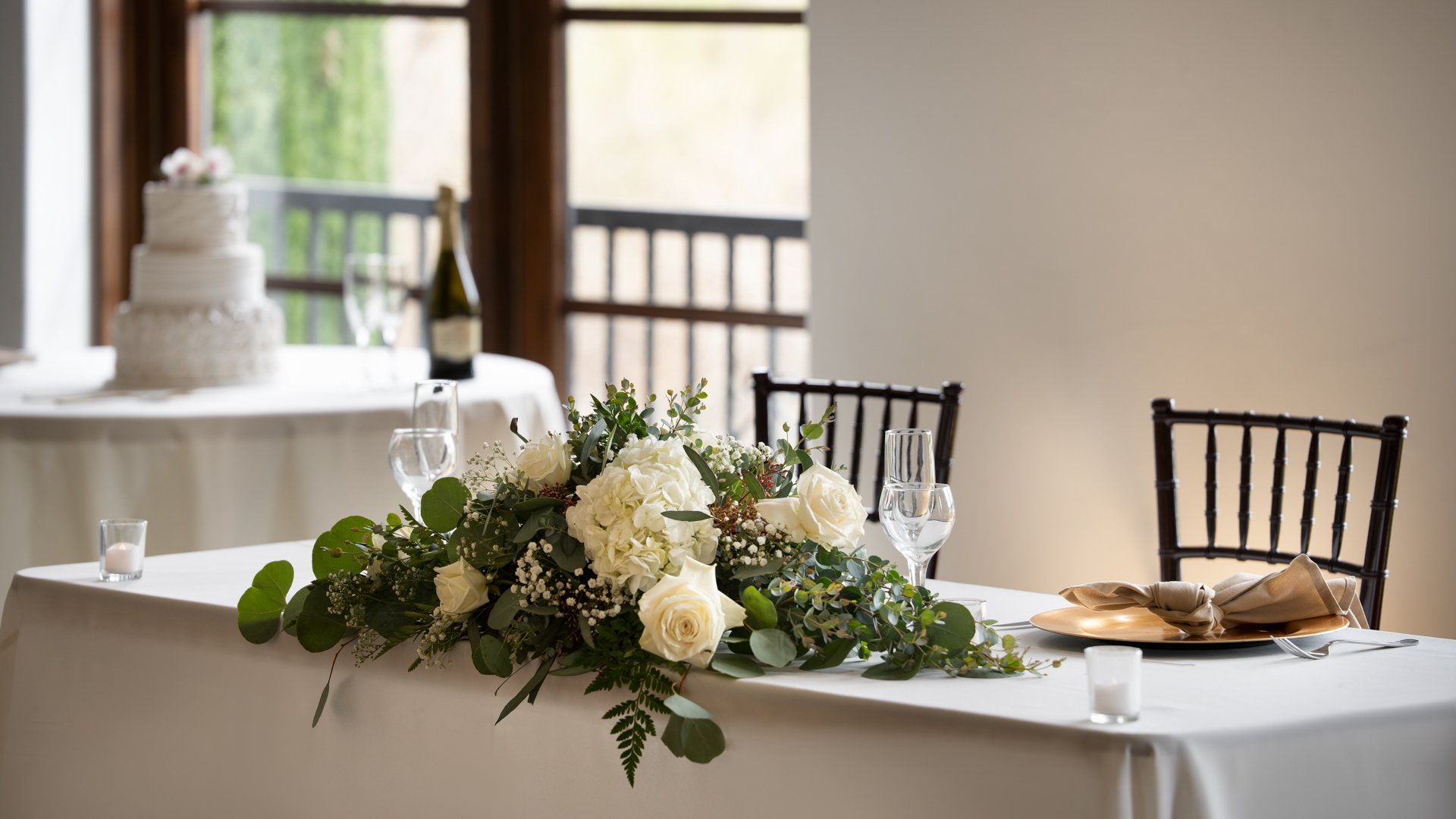 Elegant wedding reception table setting at Fallbrook Estate by Wedgewood Weddings with white roses centerpiece, champagne napkins, crystal glassware and Chiavari chairs