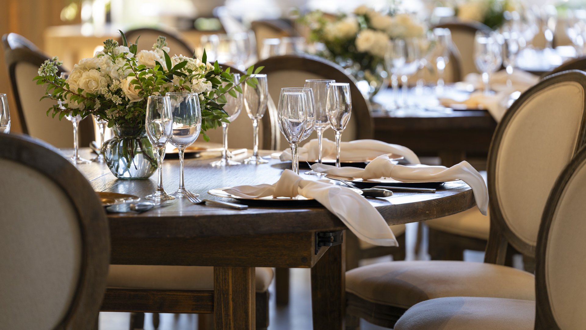 Sophisticated wedding table setting at Galway Downs with white floral centerpieces, crystal stemware, neutral linens, and elegant place settings for intimate receptions in Temecula, California