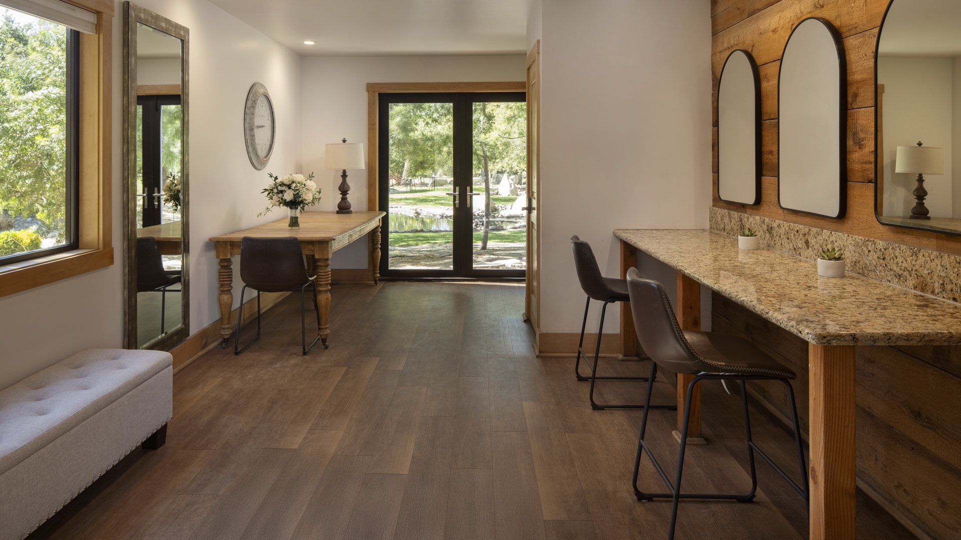 Spacious preparation room in Galway Downs Wedding Suites featuring granite vanity counters, rustic wood accents, natural lighting, and garden views for getting ready in Temecula