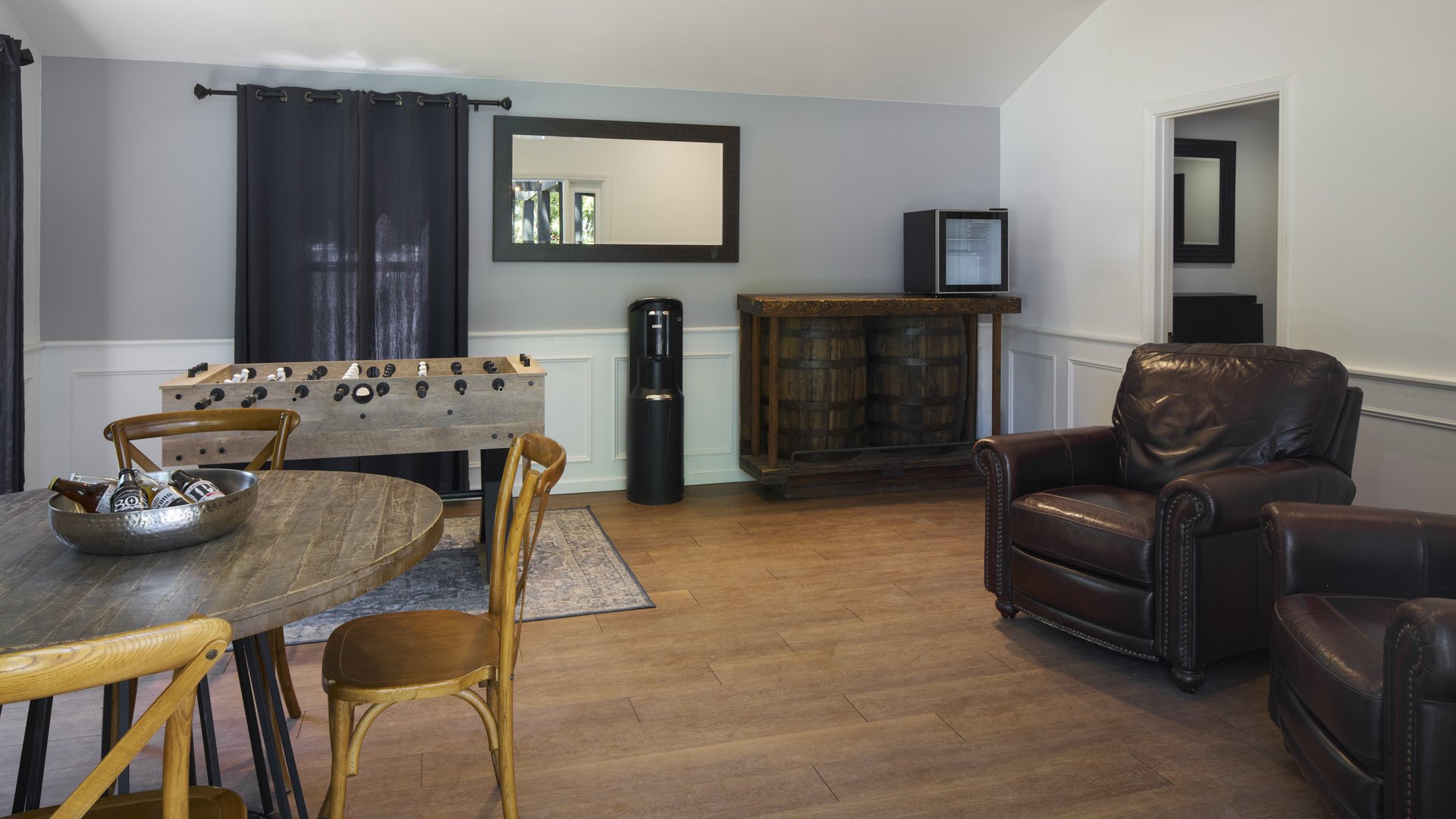 Fun entertainment room in Galway Downs Wedding Suites featuring foosball table, leather seating, rustic decor, and comfortable amenities for wedding party enjoyment in Temecula, California