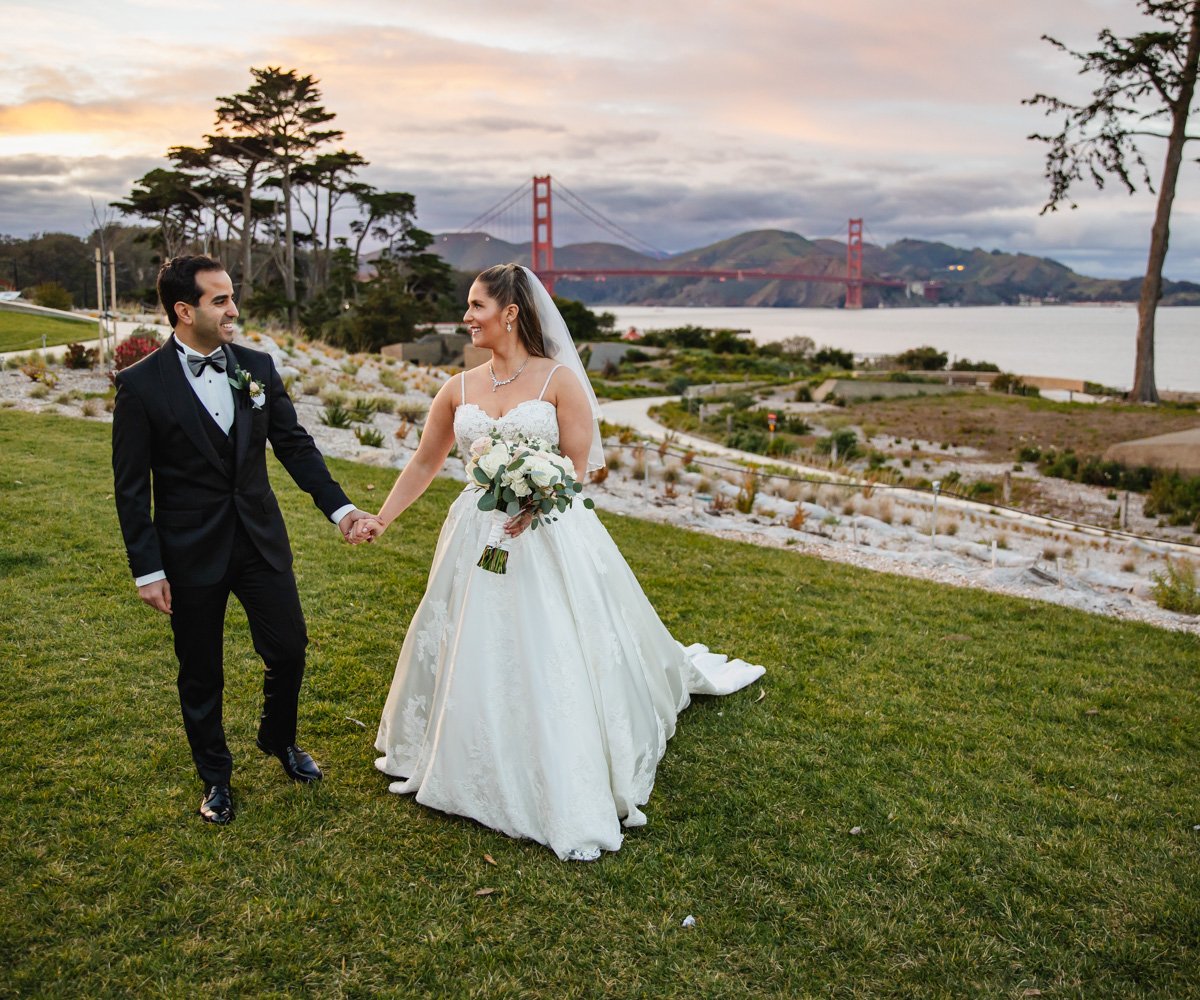 Newlyweds walking in front of the Bay area and Golden Gate Bridge - Golden Gate Club at the Presidio - Wedgewood Weddings - 6