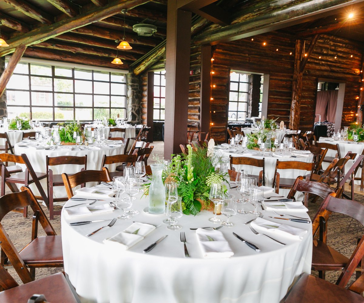 Lush green foliage on white linen table cloths in historic cabin - Log Cabin at the Presidio - Wedgewood Weddings - 1