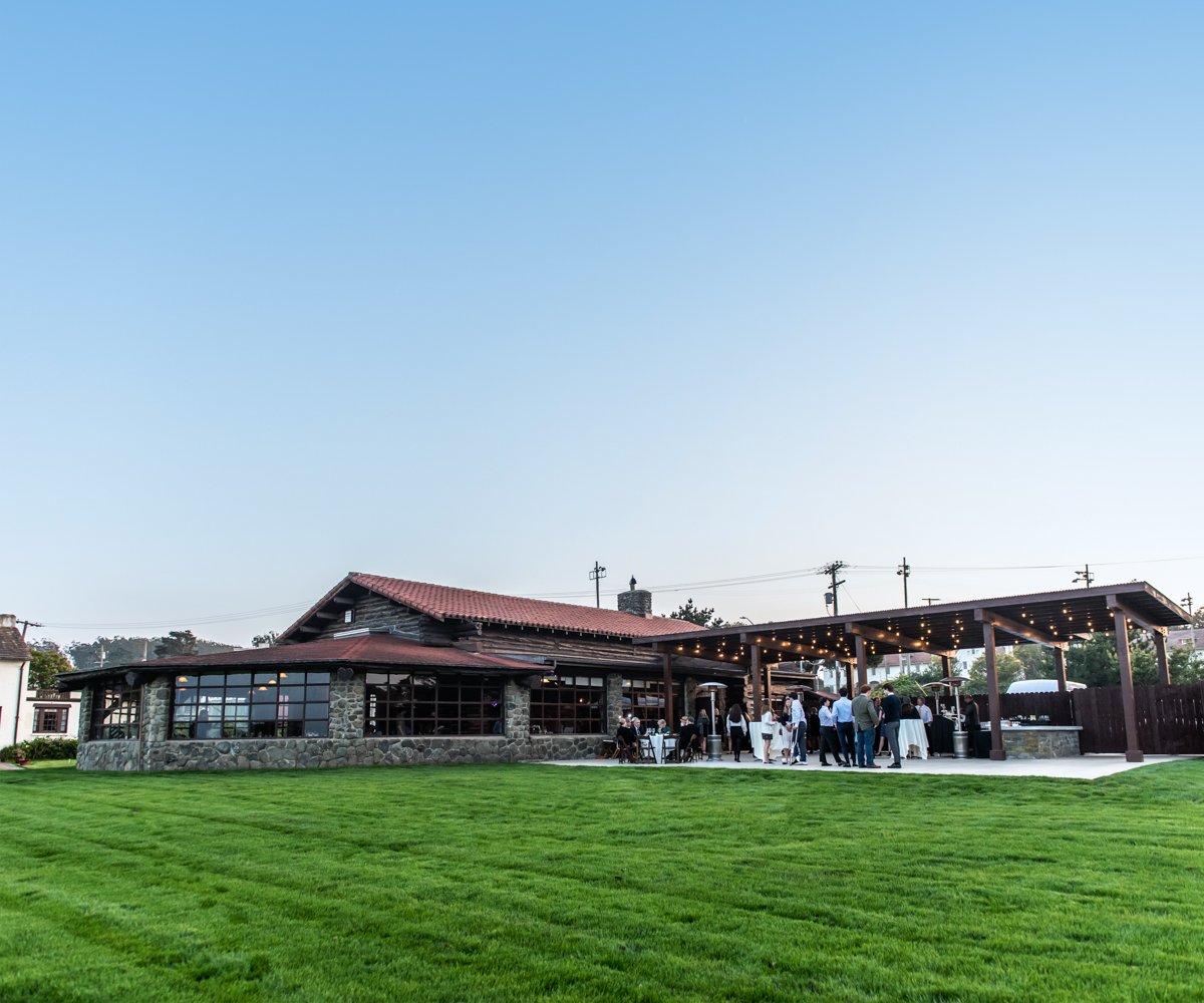 Outdoor patio with bistro lights and a vast green event lawn - Log Cabin at the Presidio - Wedgewood Weddings - 1