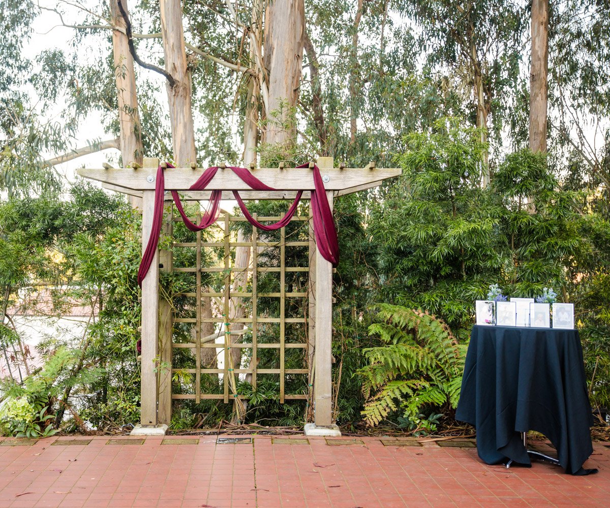 Ceremony arbor with burgundy drapery and a memorial table - Presidio Chapel at the Golden Gate Club - Wedgewood Weddings