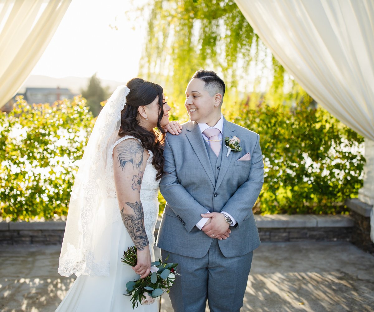 Bride and bride smiling at each other after ceremony - LGBTQ wedding - San Ramon Waters by Wedgewood Weddings