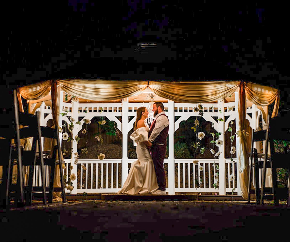 Bride and groom posing under the ceremony gazebo at night - Tapestry House by Wedgewood Weddings