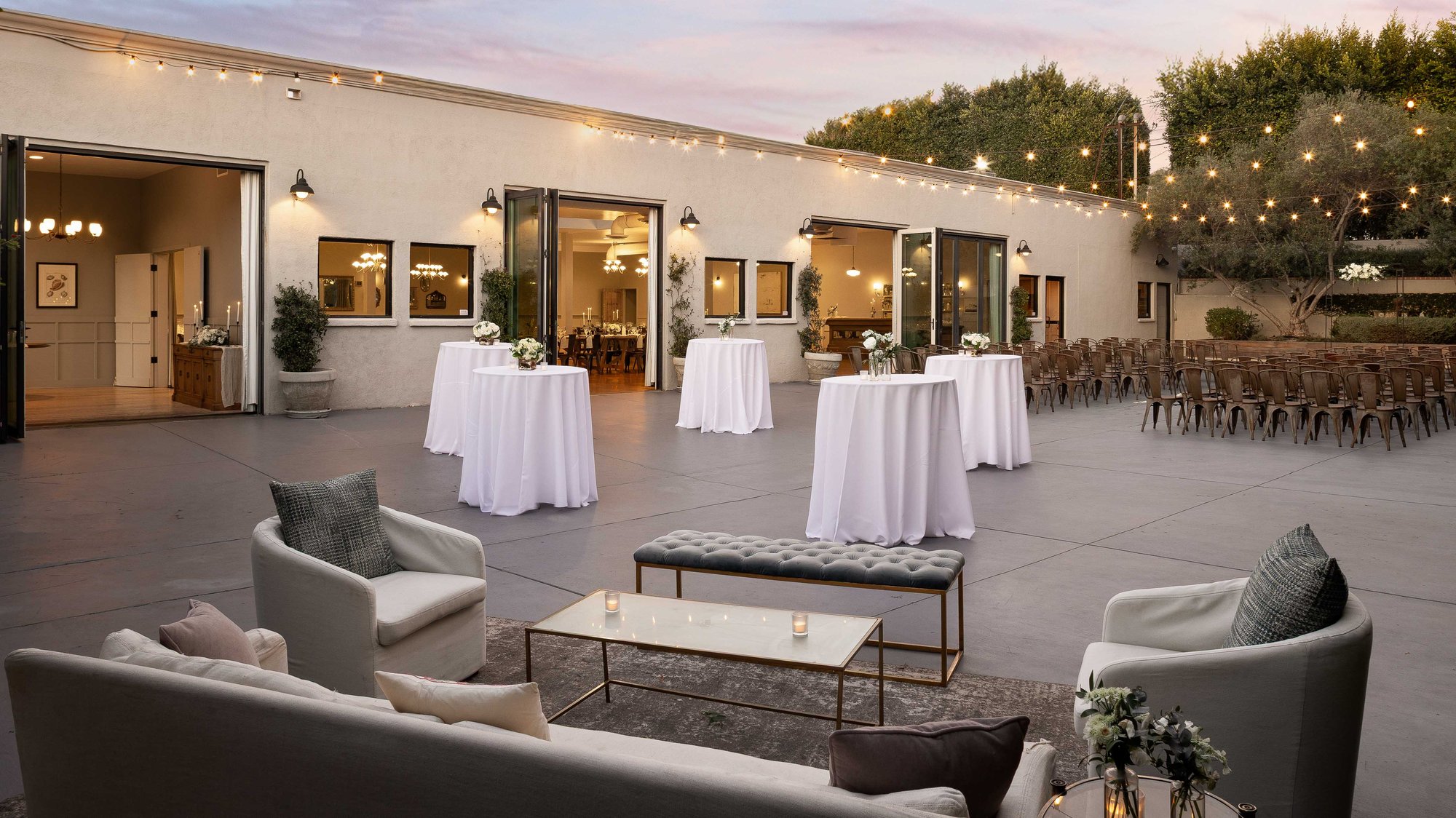 An outdoor courtyard with cocktail tables and lounge furniture