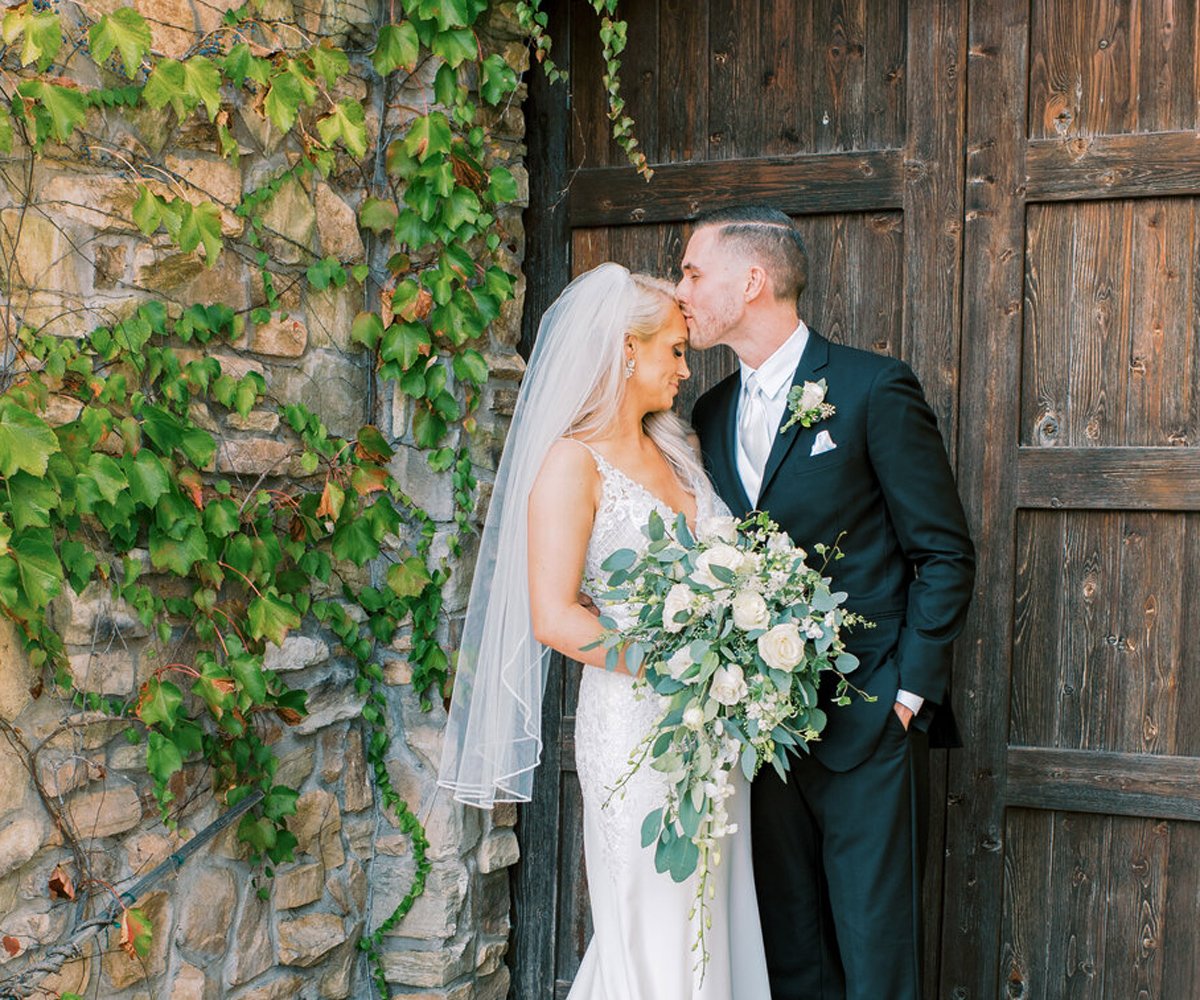 Bride-and-groom-in-front-of-wooden-door---Winchester-Estate-by-Wedgewood-Weddings